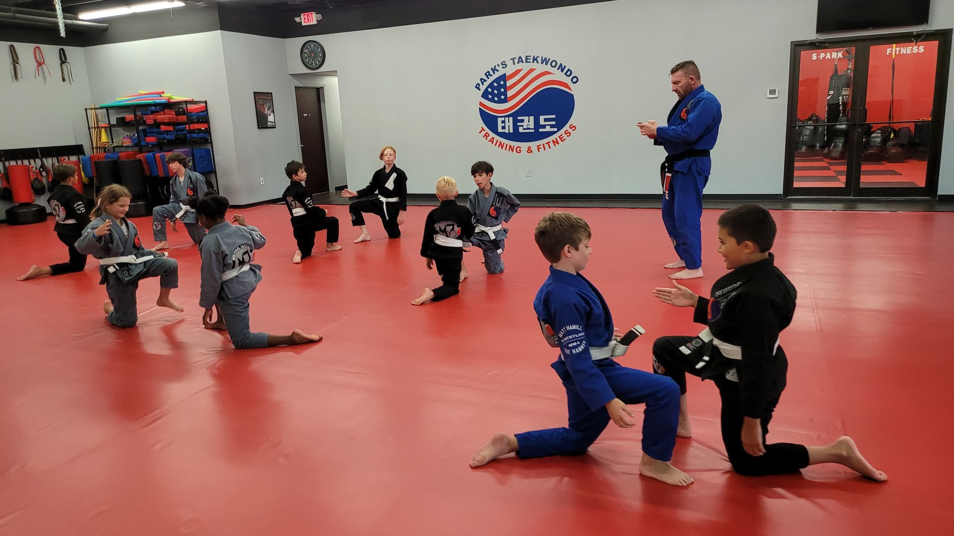 A group of young boys are practicing martial arts in a gym.