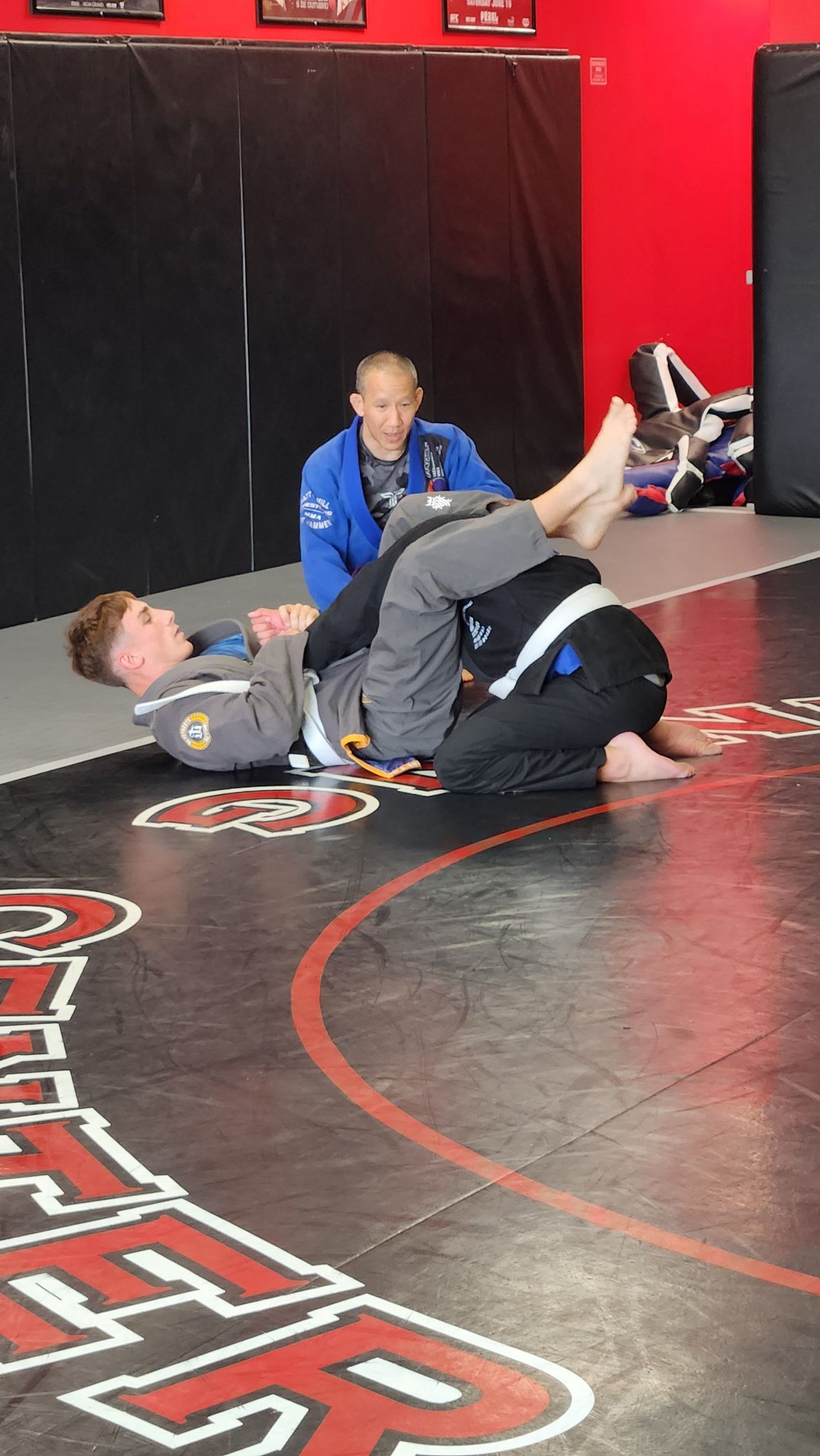 A man and a woman are practicing karate in a gym.