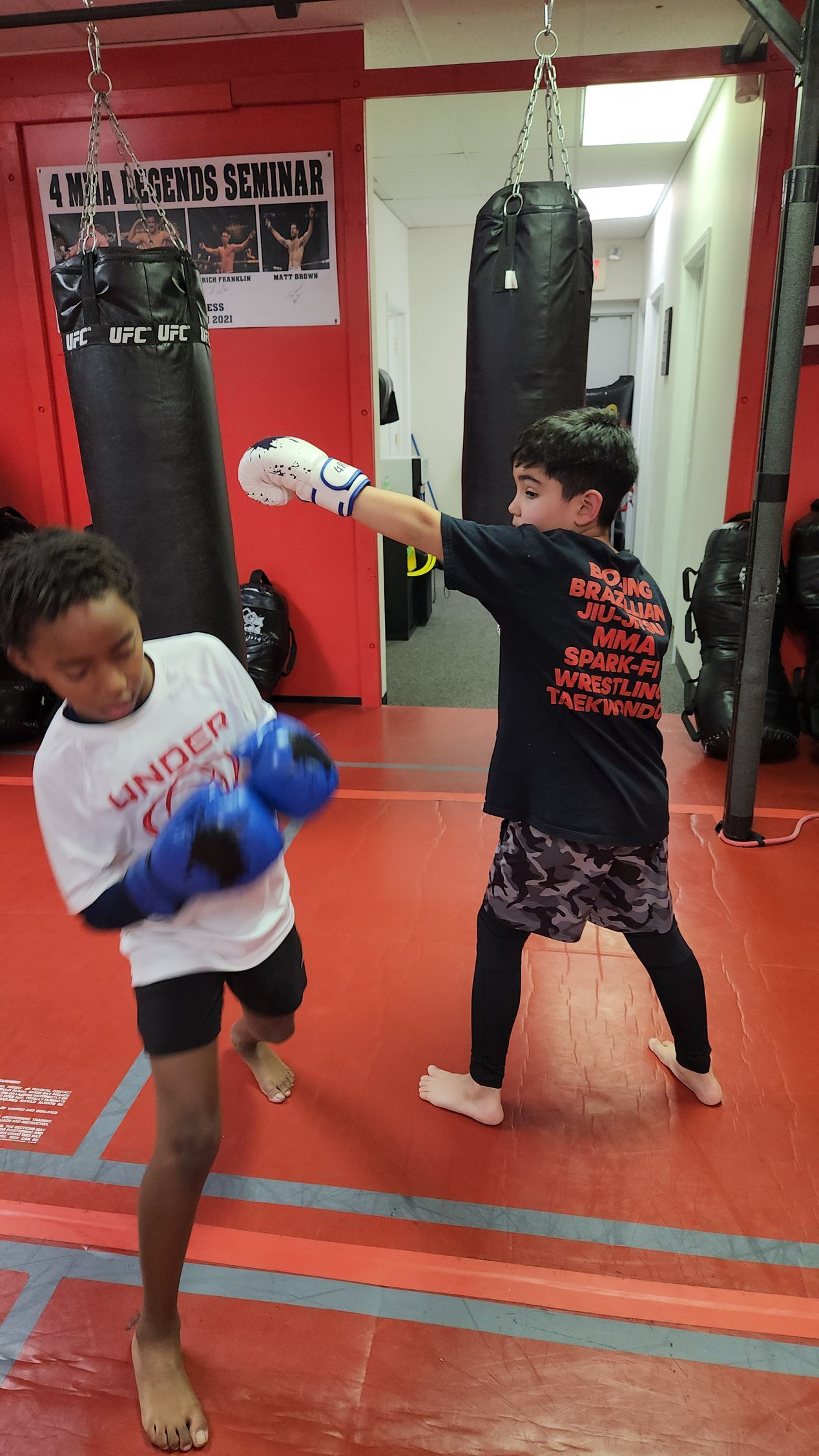 A young boy is practicing karate on a wooden floor.