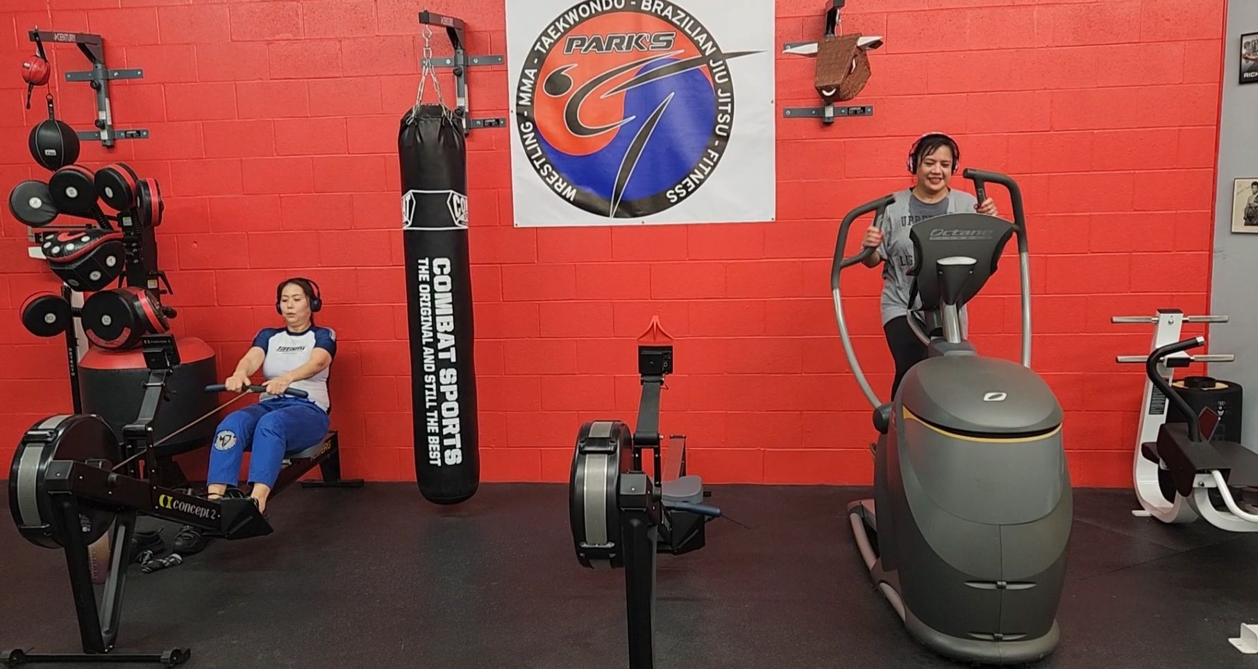 A woman is sitting on a bench in a gym next to a machine.