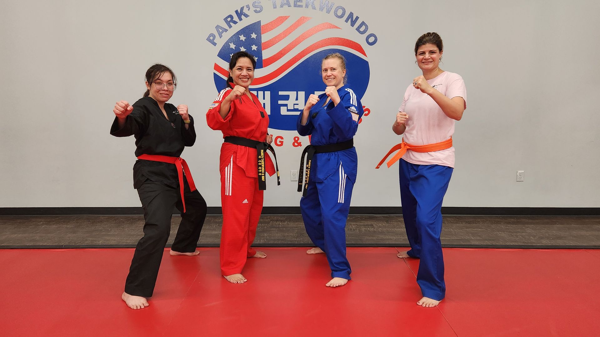 A group of women are practicing martial arts in a gym.