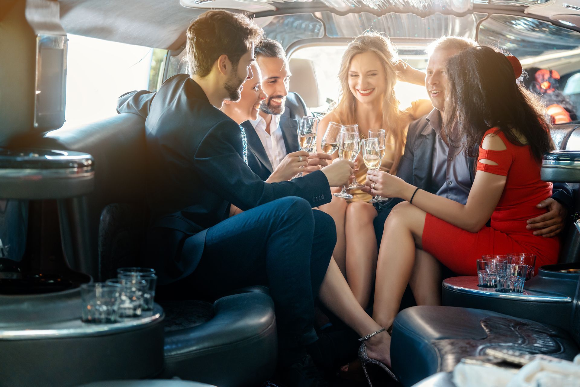 People toasting champagne in a limousine, celebrating with smiles and dressed for a special event
