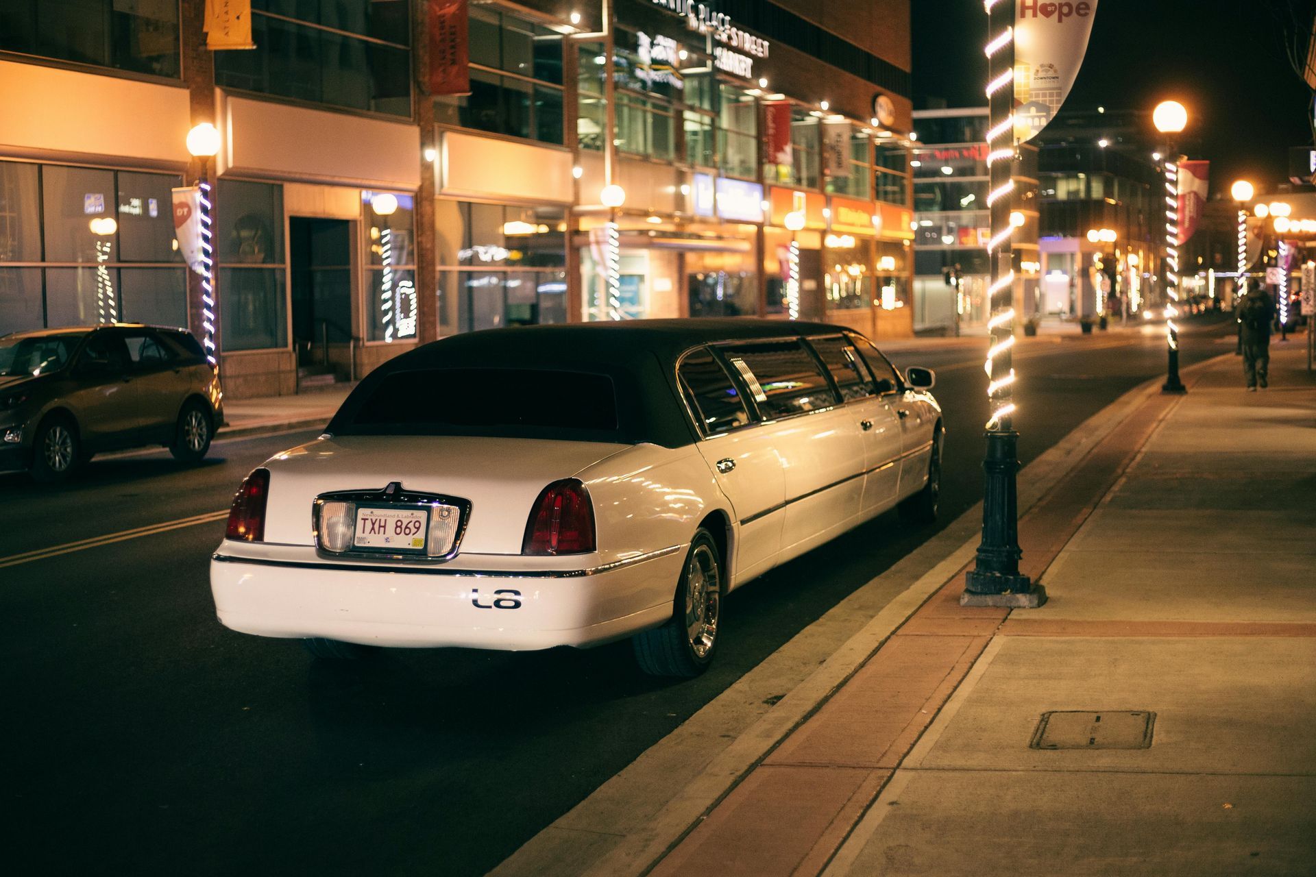 White limousine parked on city street at night