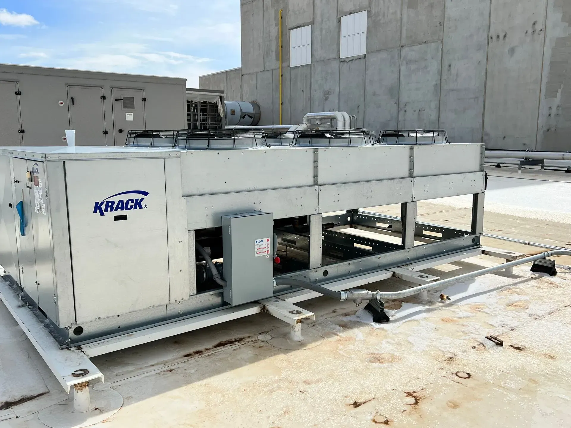 A kraack air conditioner is sitting on top of a concrete roof.