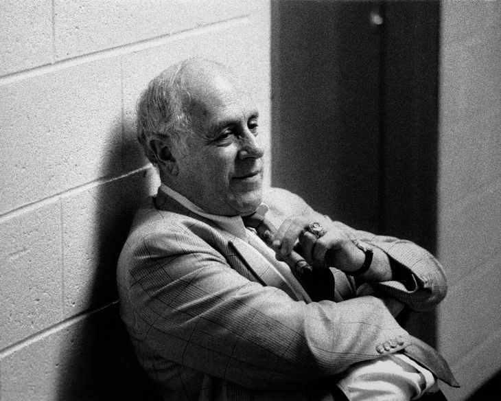 A man leaning against a brick wall with his arms crossed