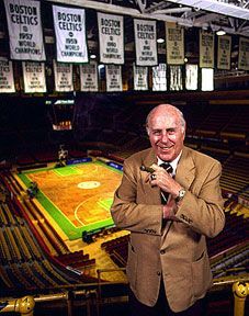 A man stands in front of a boston celtics basketball court