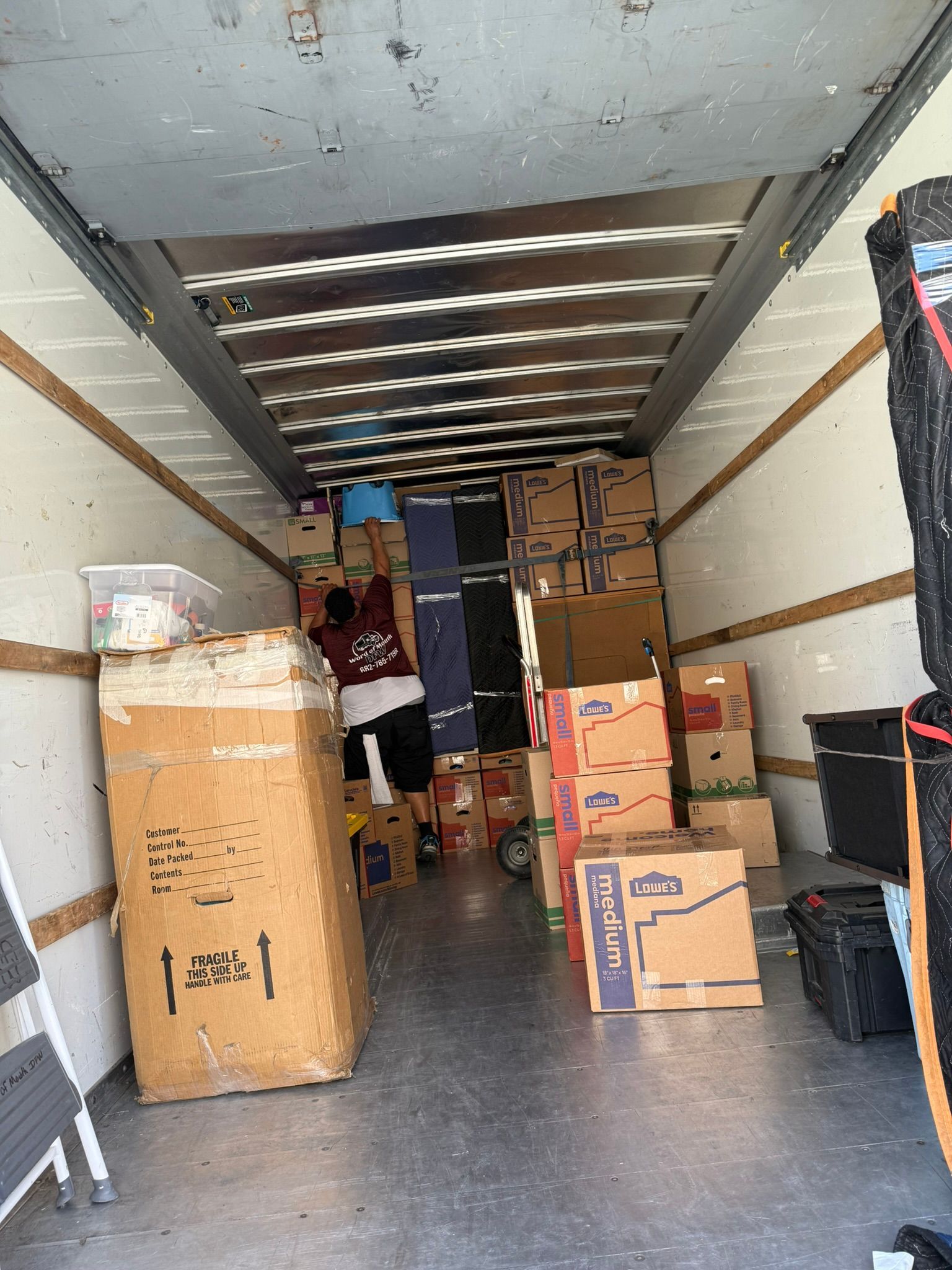 Inside a moving truck filled with boxes and belongings, ready to be transported.