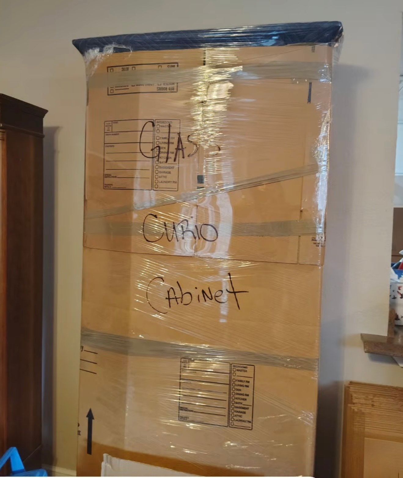 Cardboard box wrapped in clear plastic labeled 