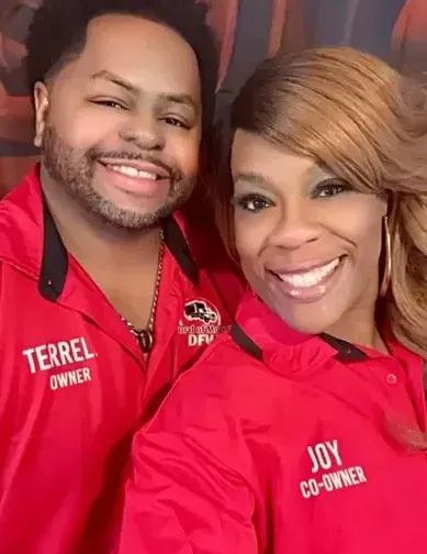 A man and a woman wearing red shirts that say joy co-owner