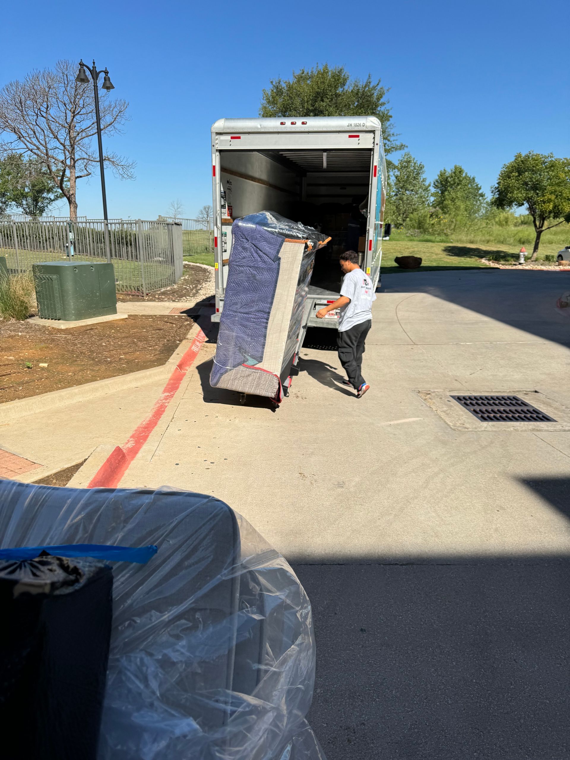 Three men are standing in front of a moving truck.