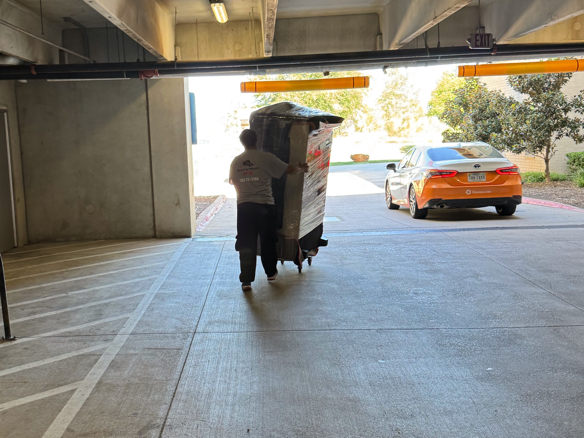 Two men are moving a couch on a dolly.