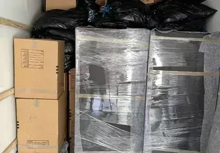 A moving truck filled with boxes and plastic bags.