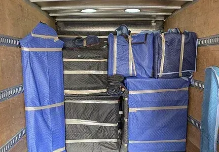 The inside of a moving truck filled with boxes and bags.