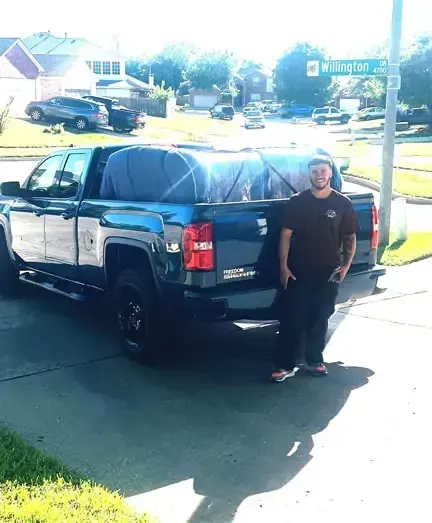 A man is standing in front of a truck that says houston