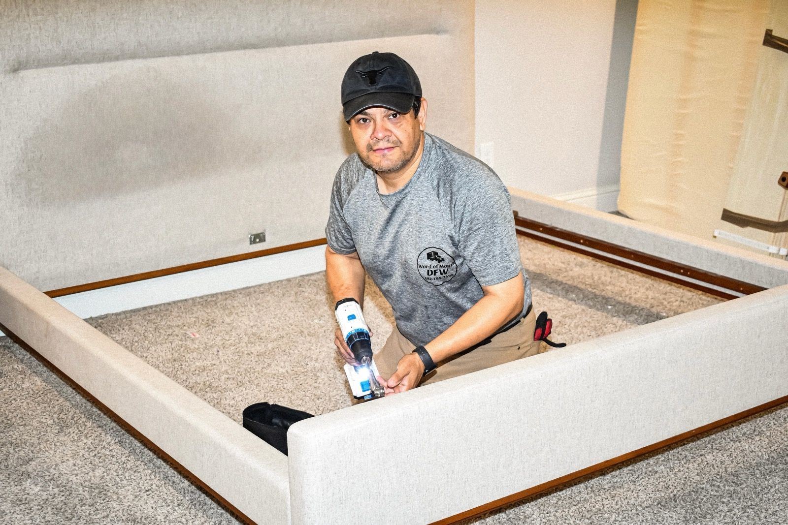 A man with dreadlocks is holding a large piece of furniture in his hands.