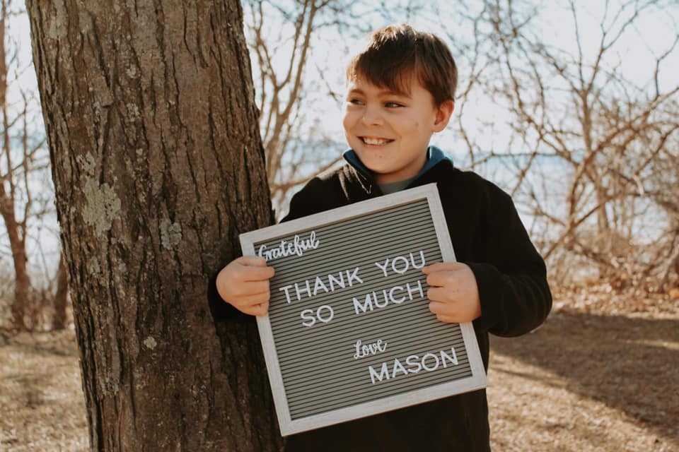 Mason holding a thank you sign.