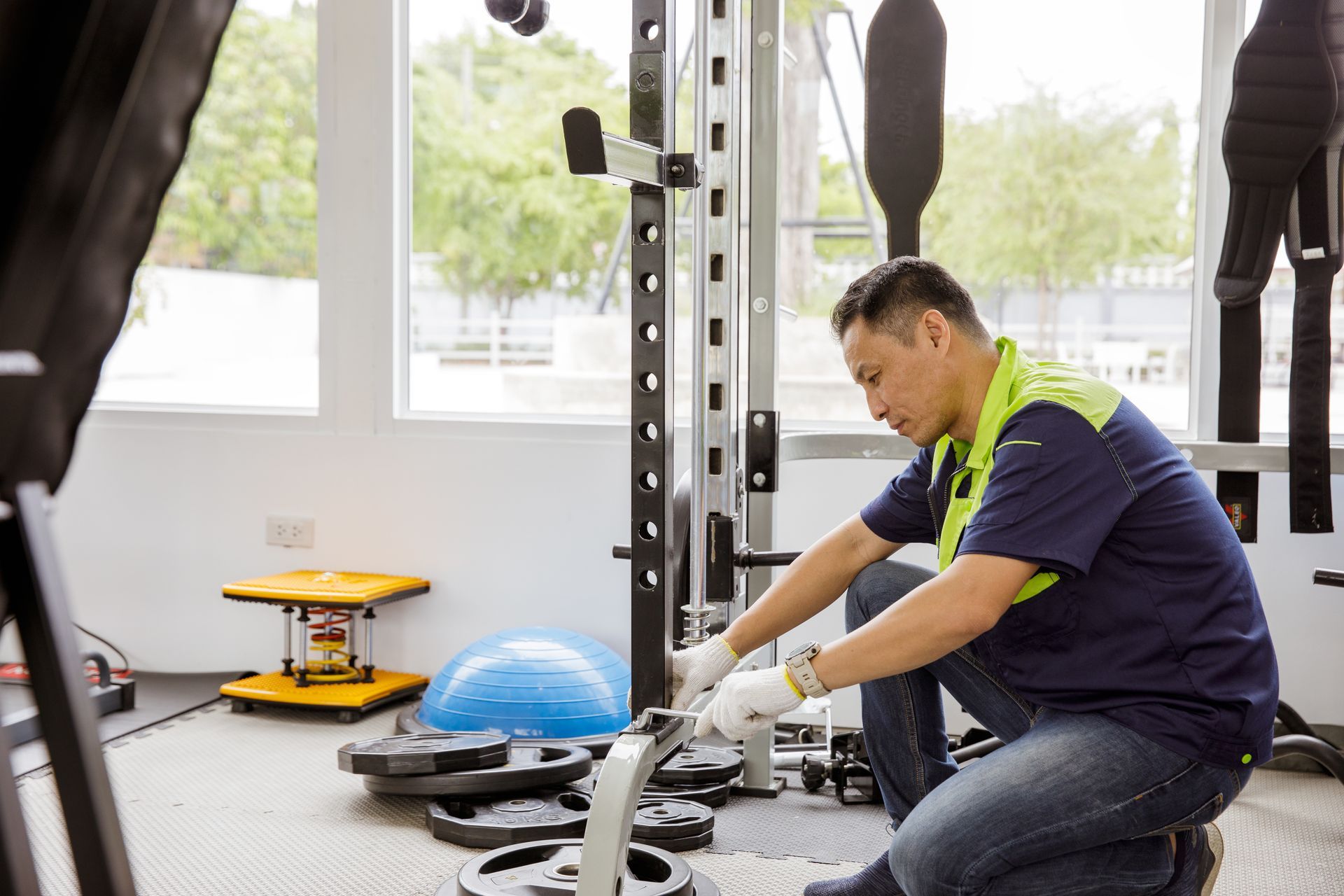 Fitness equipment repair technician servicing a gym cable machine