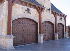 A row of wooden garage doors on a stone building.
