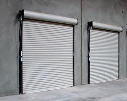 Two white roller shutters are sitting next to each other on the side of a building.