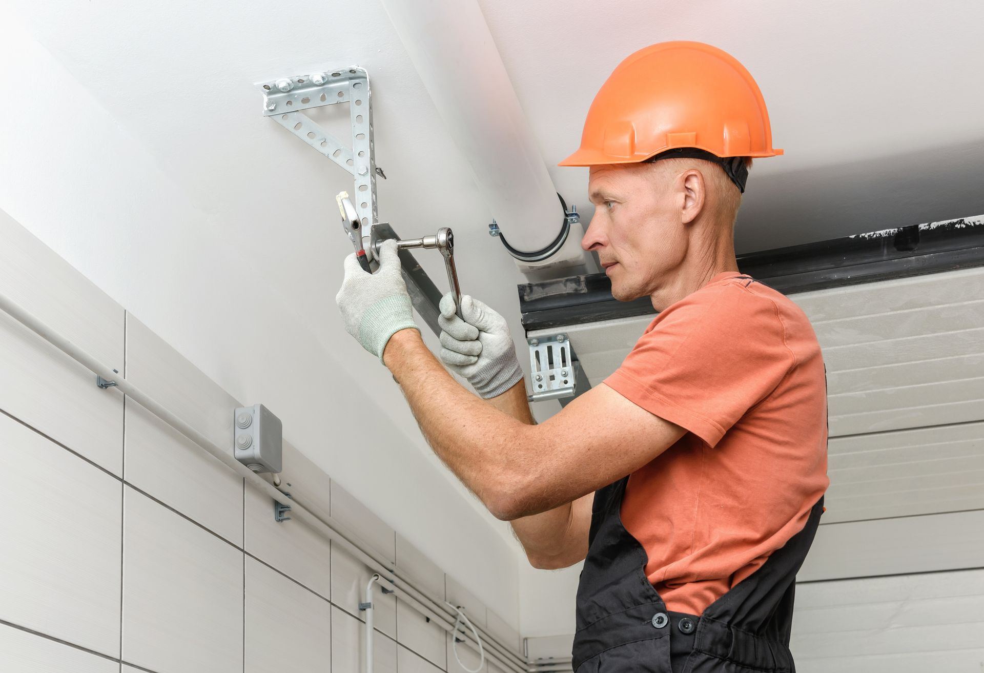 A man is installing a garage door in a garage.
