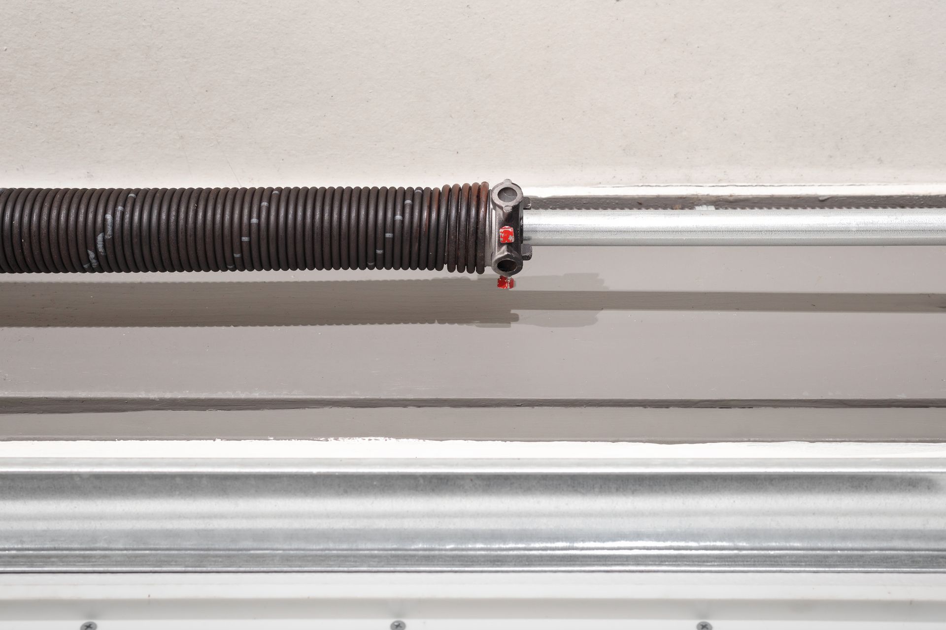 A close up of a garage door spring on a garage door.