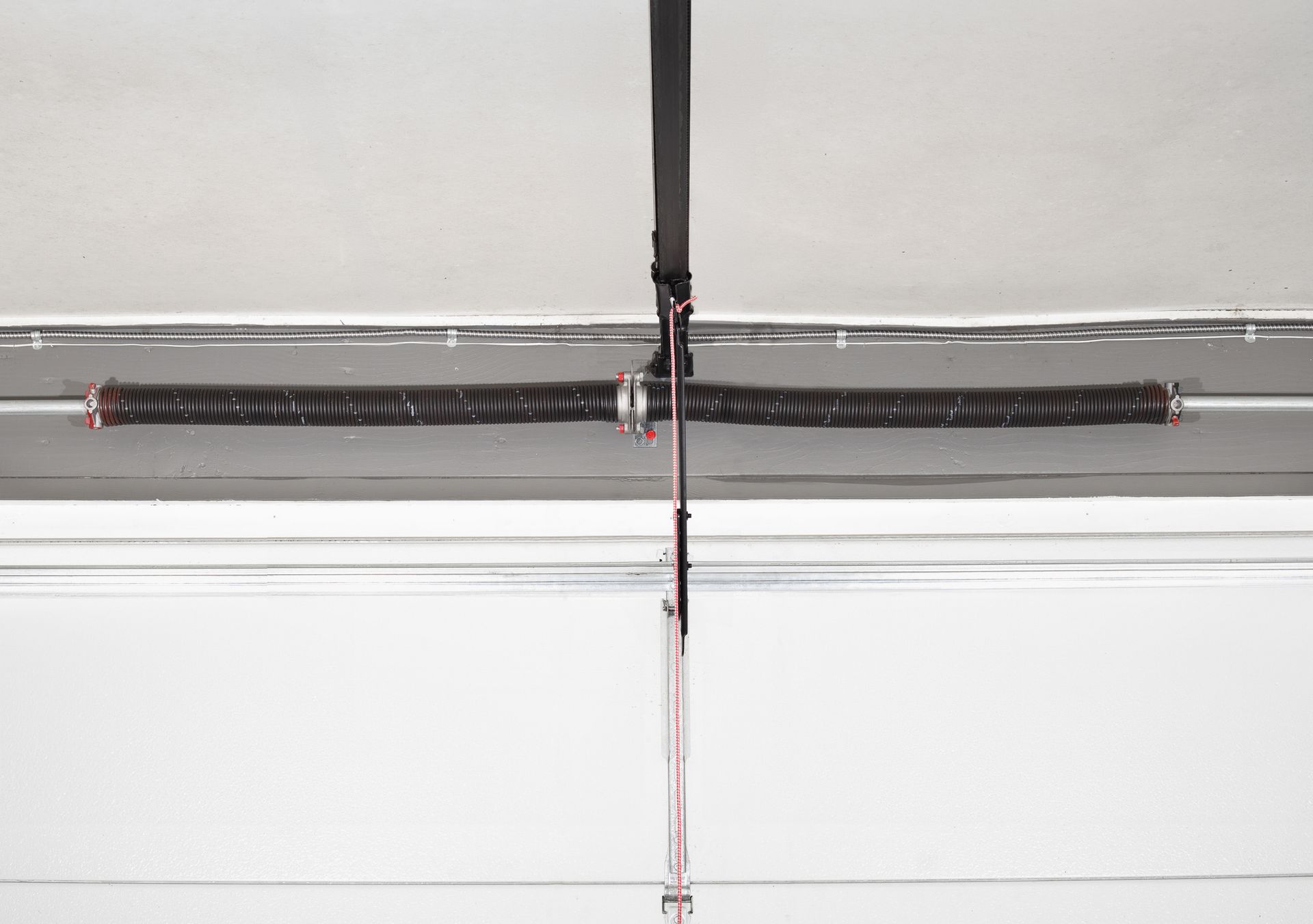 A close up of a garage door spring on a garage door.