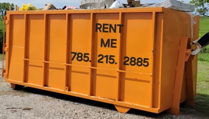 An orange industrial dumpster with the words 