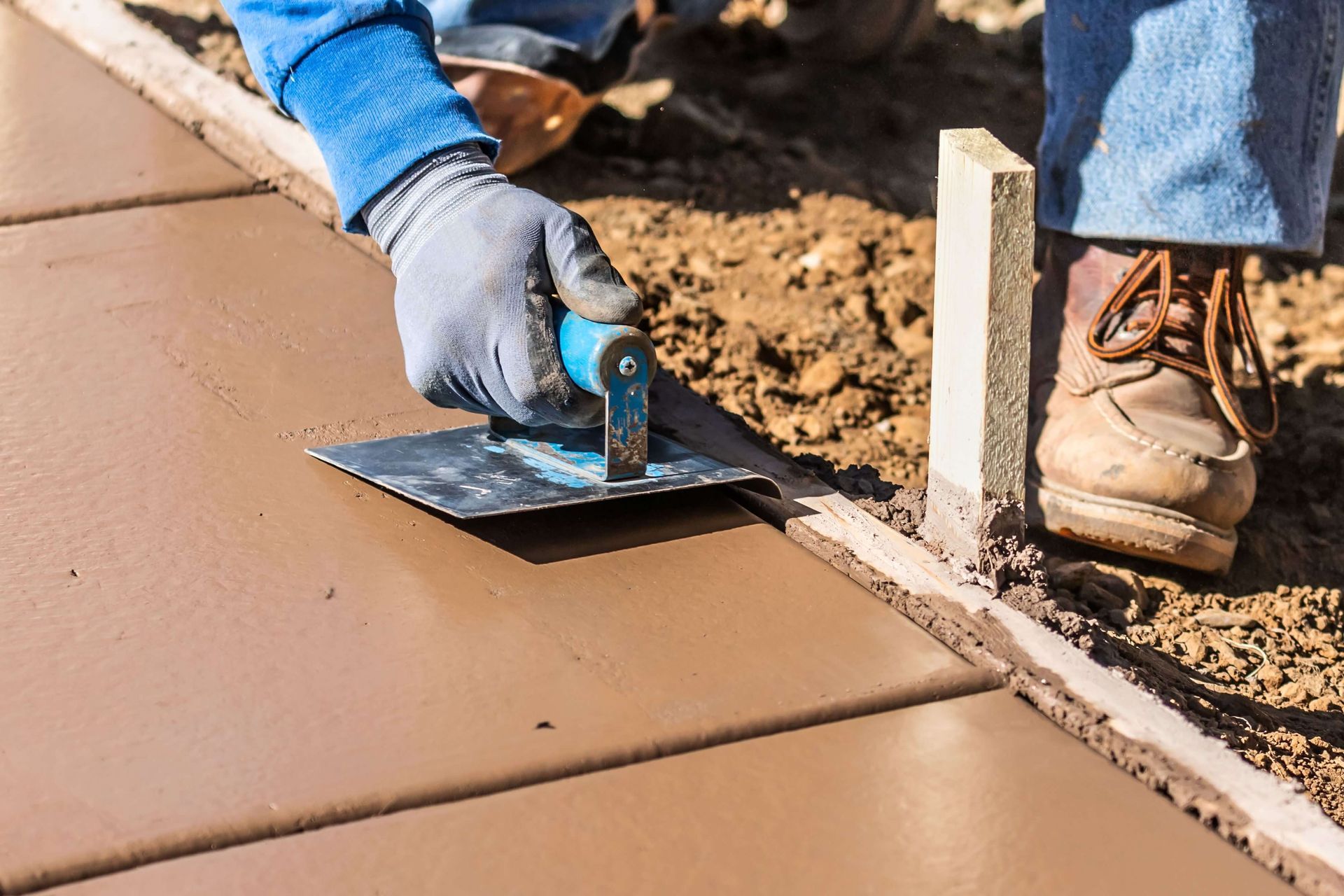 concrete contractor laying down concrete, shaping concrete with tools, concrete contractors benton ar, concrete driveways, stamped concrete, concrete services in benton arkansas