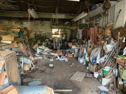a messy room filled with lots of junk and boxes .