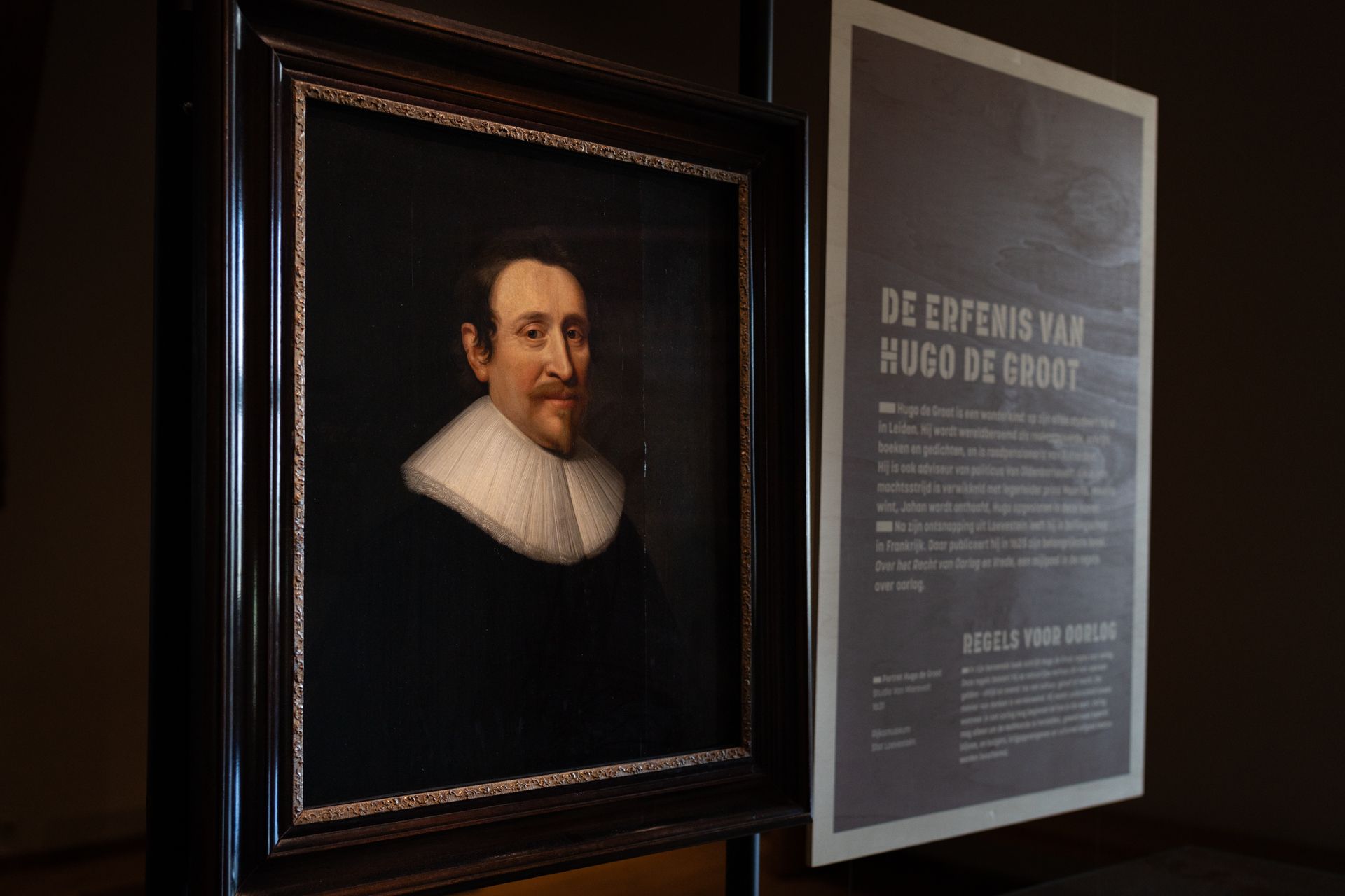 Framed portrait beside a museum plaque titled “De grootste… Hugo de Groot”