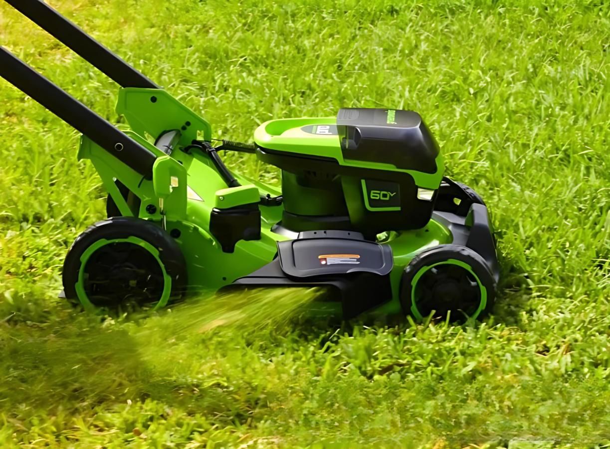 A Green and Black Lawn Mower is Cutting a Lush Green Lawn — Diamond Service Centre In Lismore, NSW