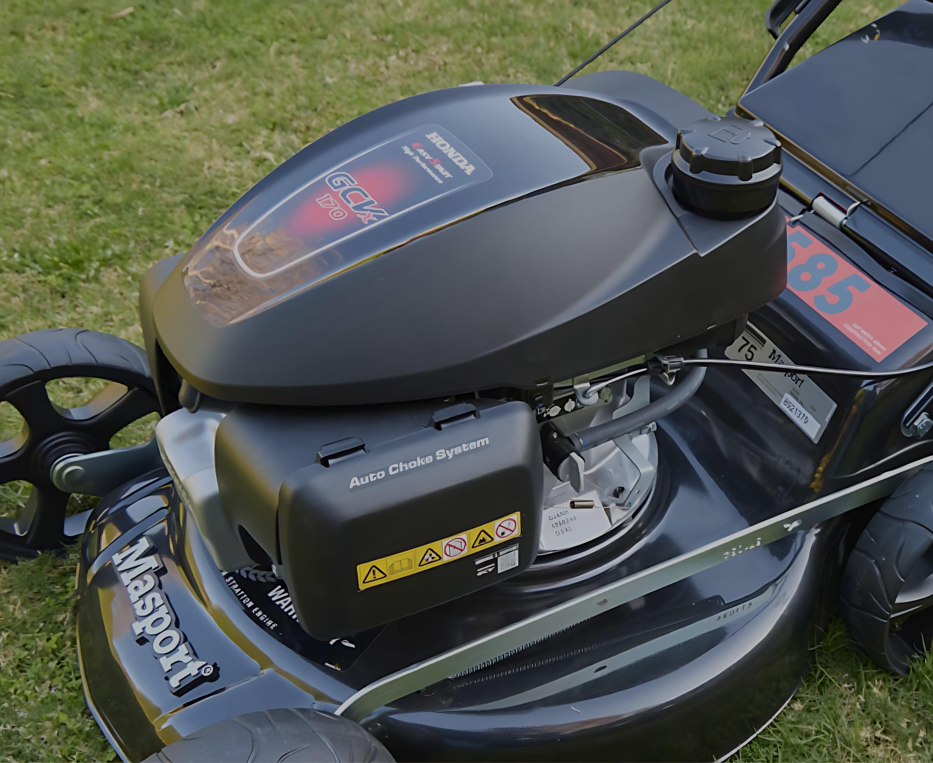A Lawn Mower , Rake , and Sprinkler Are Sitting on a Lush Green Lawn — Diamond Service Centre In Lismore, NSW