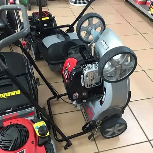 A Person is Pushing a Green and Black Lawn Mower on a Lush Green Lawn — Diamond Service Centre In Lismore, NSW