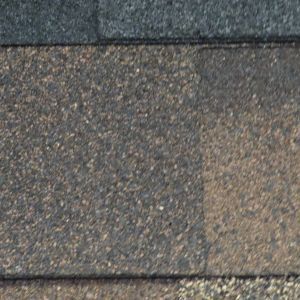 Close-up of gray asphalt shingles with a darker top edge