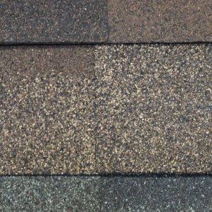 Three rows of weathered asphalt roof shingles in gray and brown tones