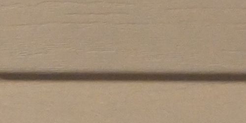 Close-up of almond vinyle siding. 