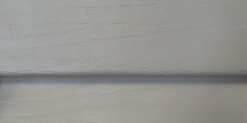 Close-up of antique ivory vinyl siding. 