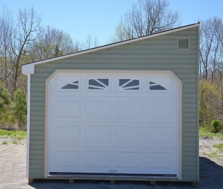 Small beige garage with a white door and windows, standing outdoors on a sunny day.