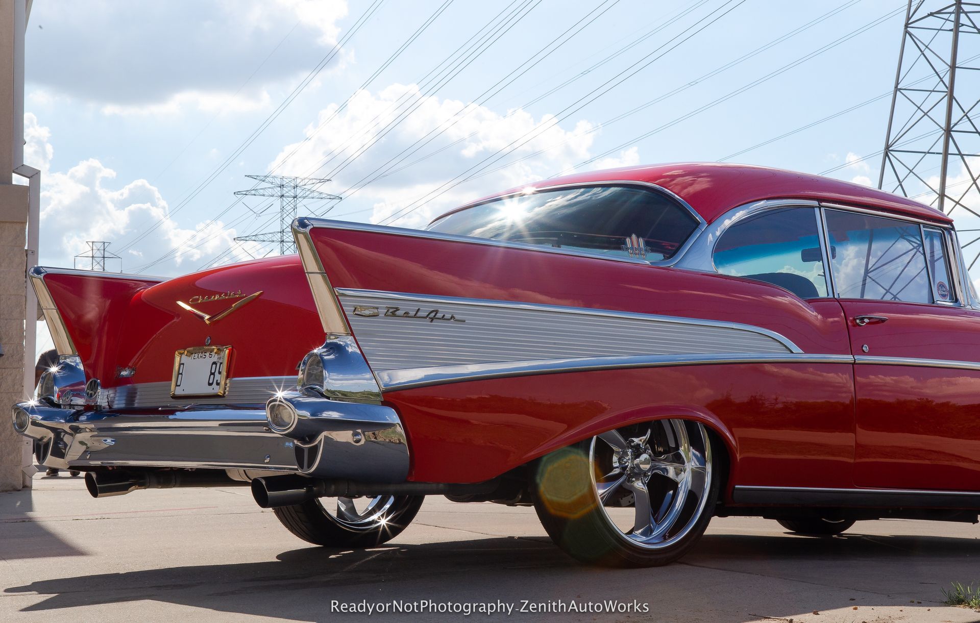 Two red classic cars with large tailfins parked outdoors.