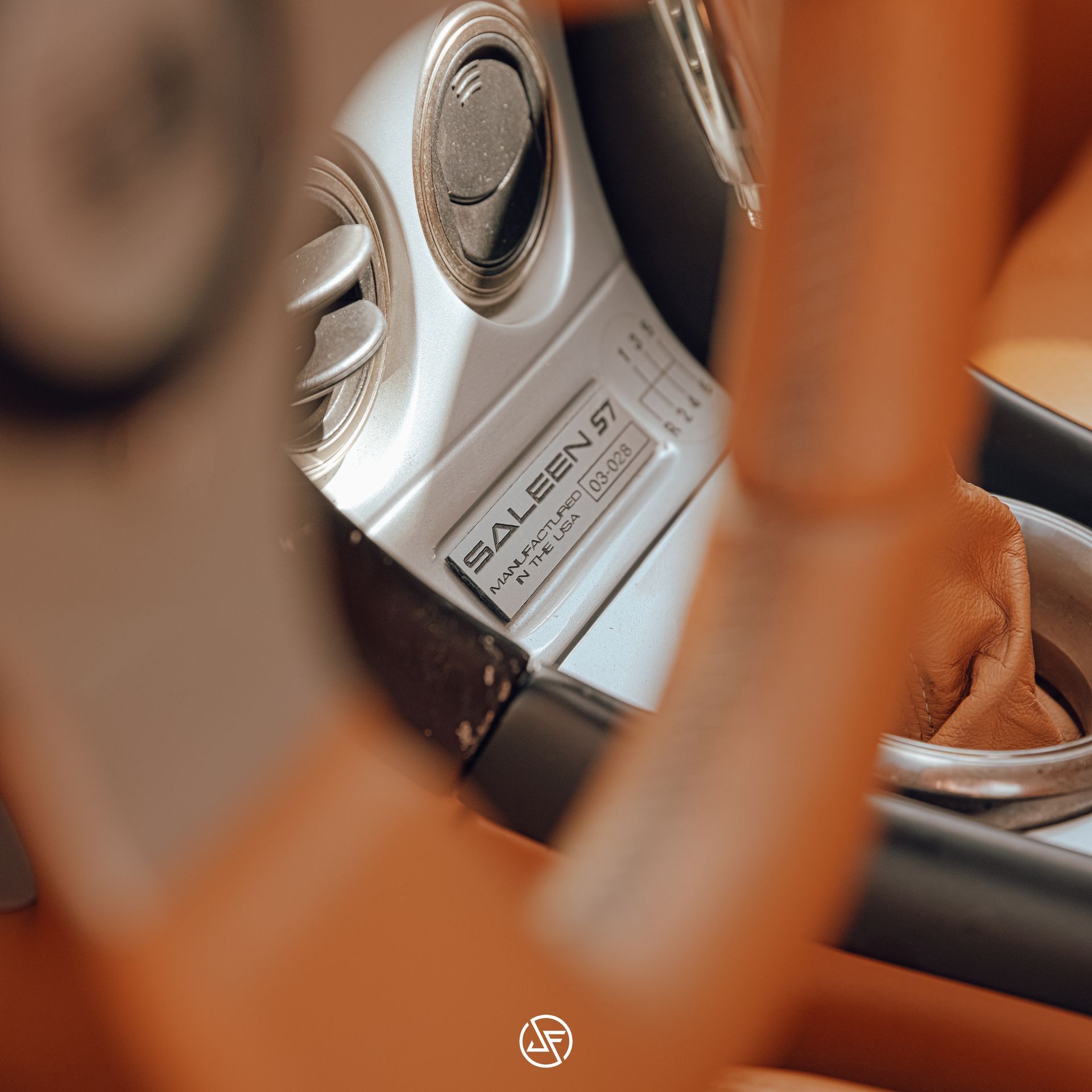 Close-up of a Saleen S7 car interior. Silver vents, gear shift, and a 