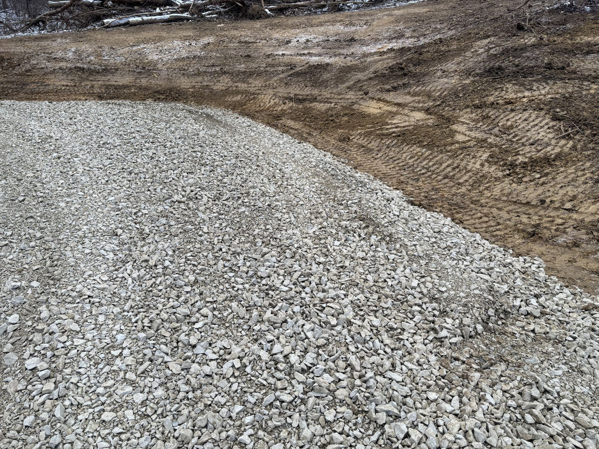 Fresh gray gravel piled on a dirt construction site