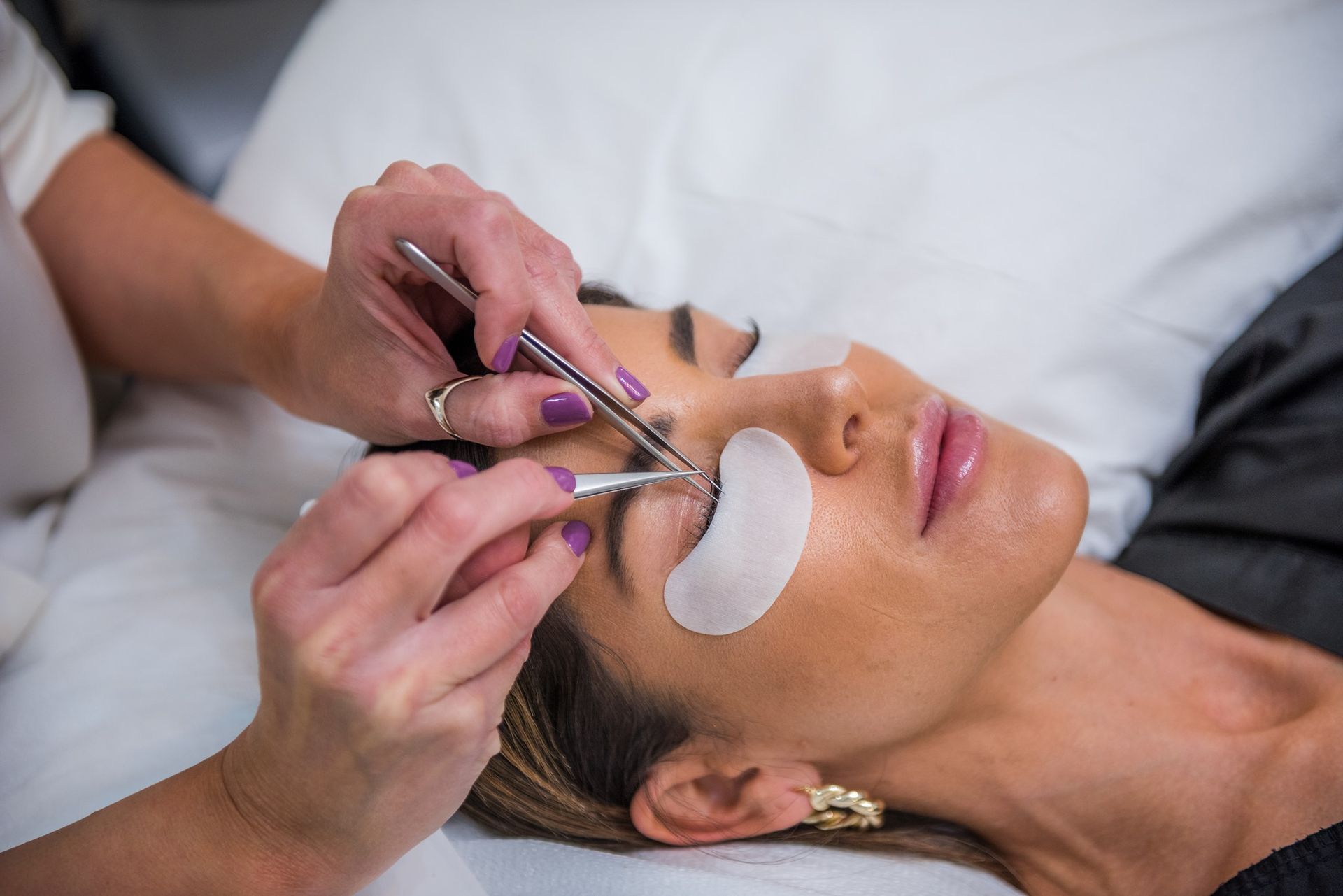 A woman is getting her eyelashes done at a beauty salon.
