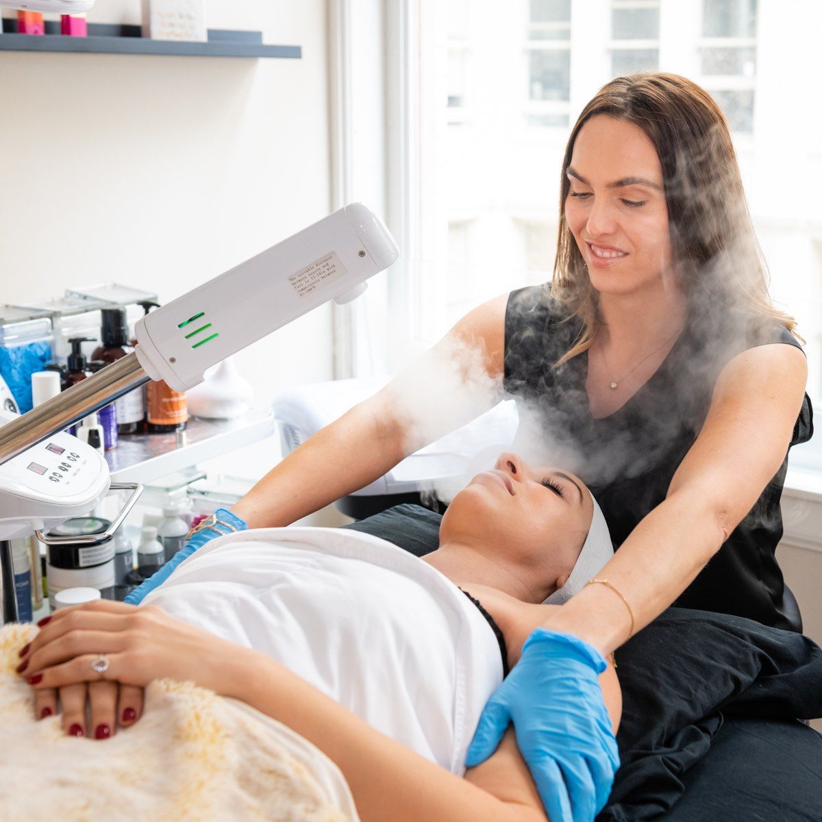 A woman is getting a steam treatment on her face