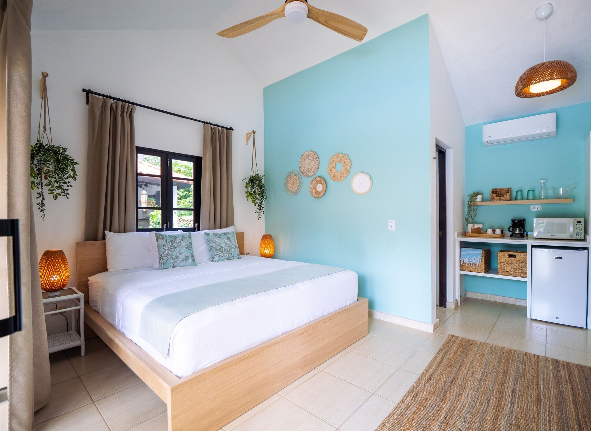 Bedroom with light wood bed frame, aqua accent wall, and beige accents.