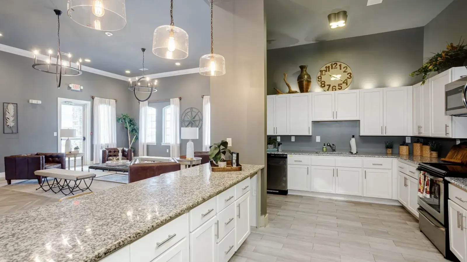 Modern open-plan kitchen with white cabinets, granite island, gray backsplash, and bright dining area