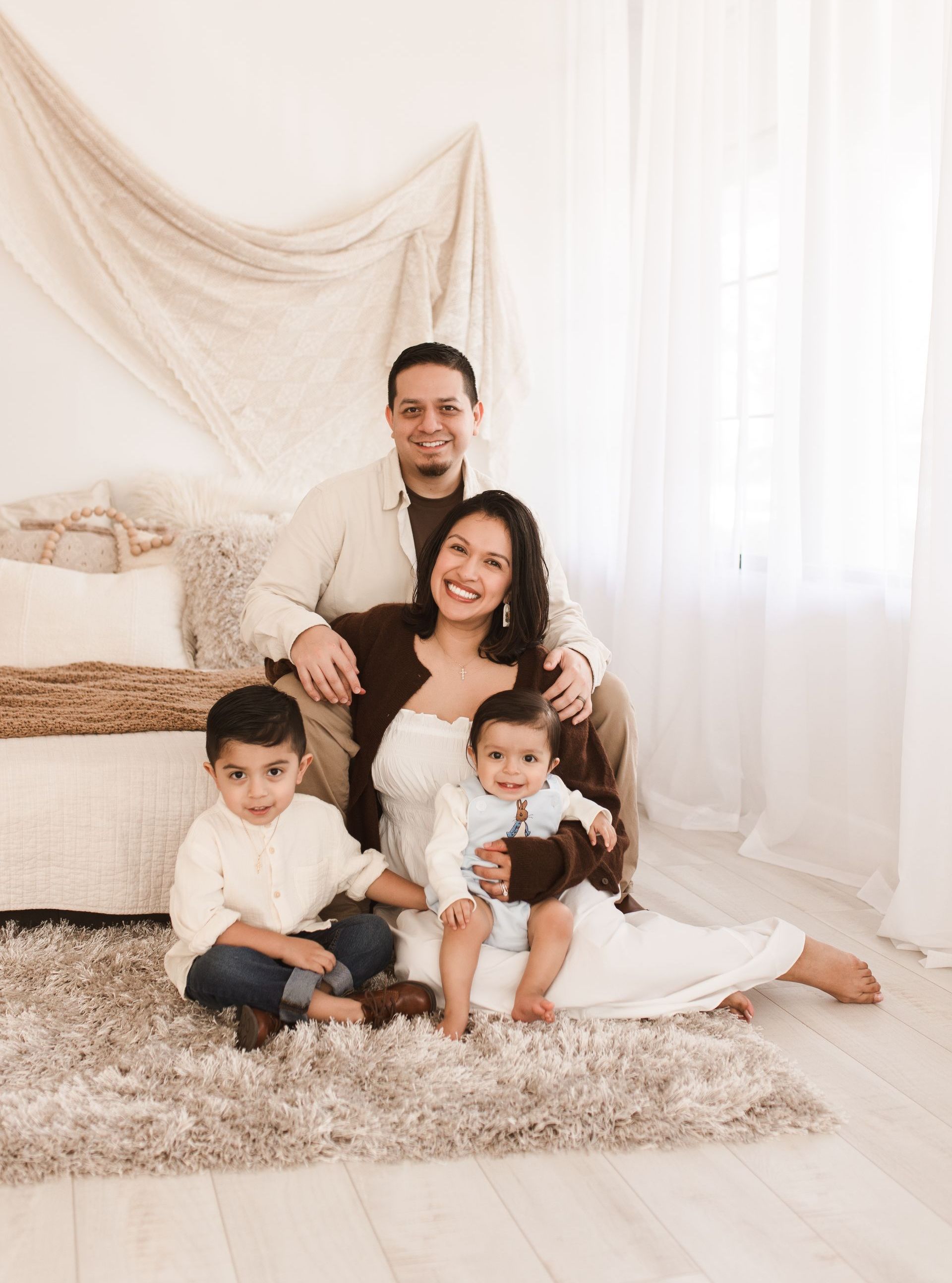 A family is posing for a picture while sitting on a bed.