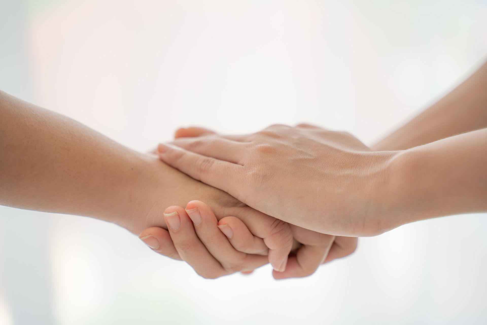 Two people are holding hands on a white background.