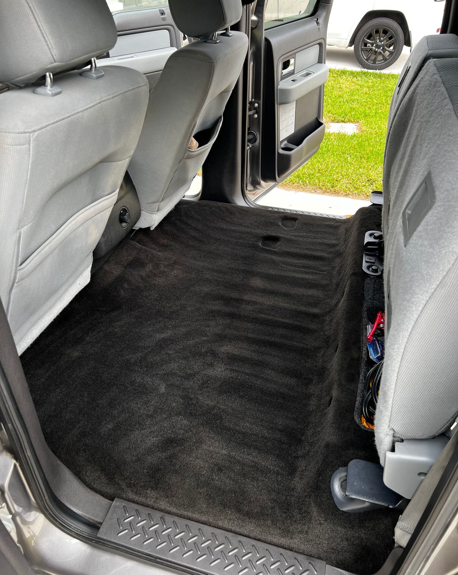 the back seat of a truck has a black carpet