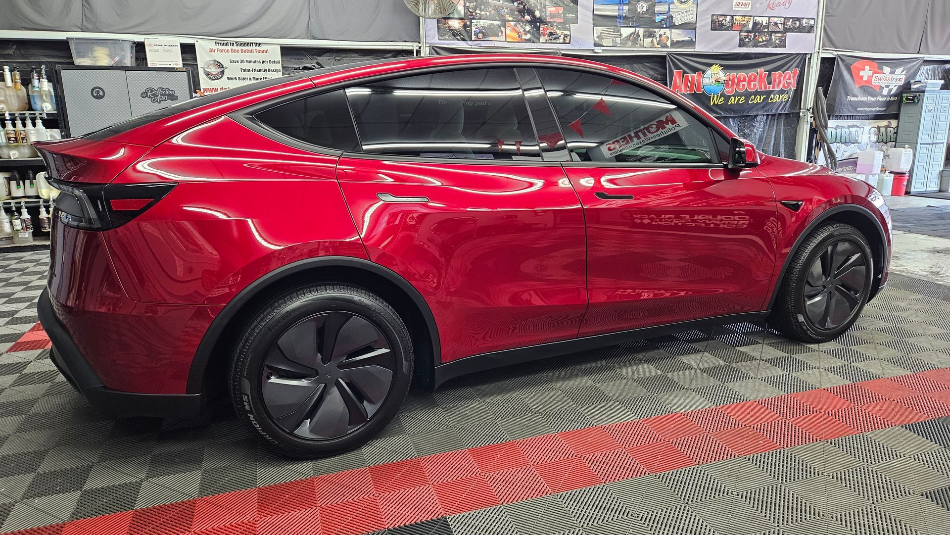 Red crossover SUV in glossy red, side view, parked indoors on a patterned floor.