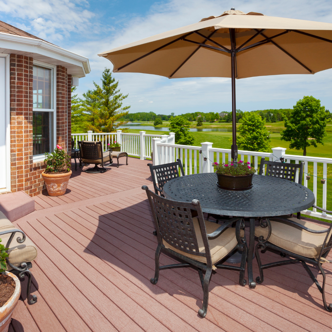 A deck with a table and chairs and an umbrella